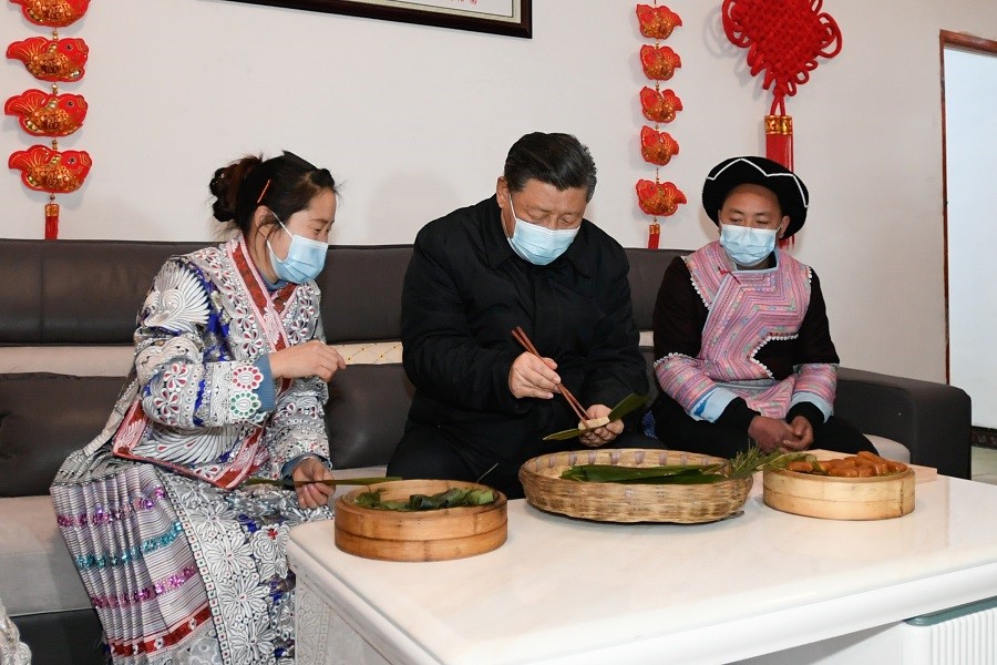 2021年2月3日下午，習(xí)近平在貴州畢節(jié)市黔西縣新仁苗族鄉(xiāng)化屋村苗族村民趙玉學(xué)家，同一家人邊聊家常邊制作當(dāng)?shù)貍鹘y(tǒng)節(jié)日食品黃粑。新華社記者 李學(xué)仁 攝